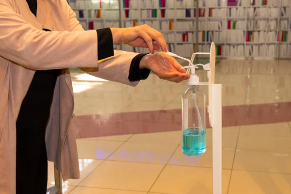 A woman disinfects her hands with gel in a store