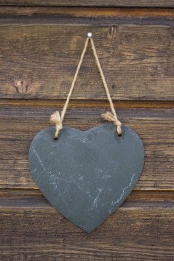 Eski ahşap duvarın önünde duran şist kalp.