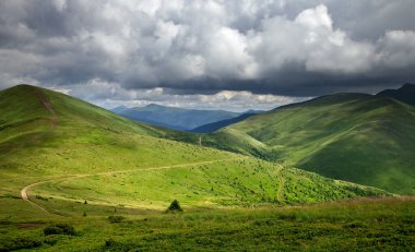 Yaz günü dağlarda, dipsiz bir gökyüzünün altında bulutlarla