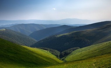 Yaz günü dağlarda, dipsiz bir gökyüzünün altında bulutlarla