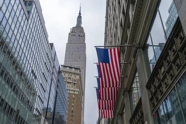 Edificio Empire State y banderas estadounidenses en la ciudad de Nueva York — Foto de Stock
