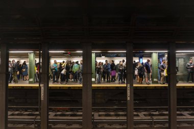Passengers waiting for train in a subway station in New York City clipart