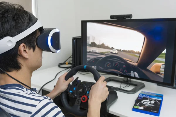 Jogar vídeo game de corrida com fone de ouvido VR em casa — Fotografia de Stock