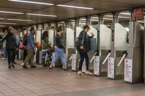 Los viajeros que pasan por los torniquetes en una estación de metro en la ciudad de Nueva York —  Fotos de Stock