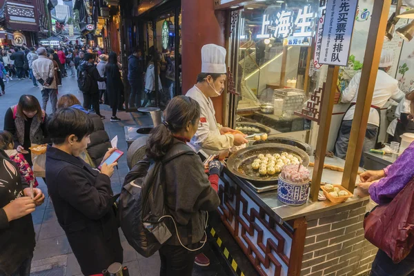 Gente comprando albóndigas fritas de Shanghai en un puesto de comida — Foto de Stock