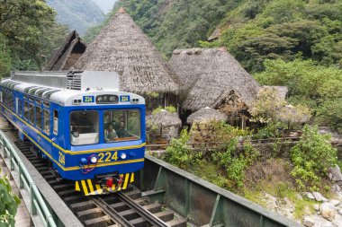 Peru Rail train arriving at Machu Picchu Station clipart