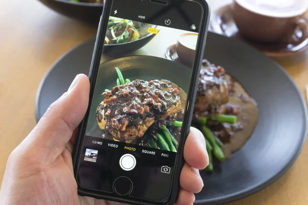 Rindersteak mit dem Smartphone fotografieren Stockbild