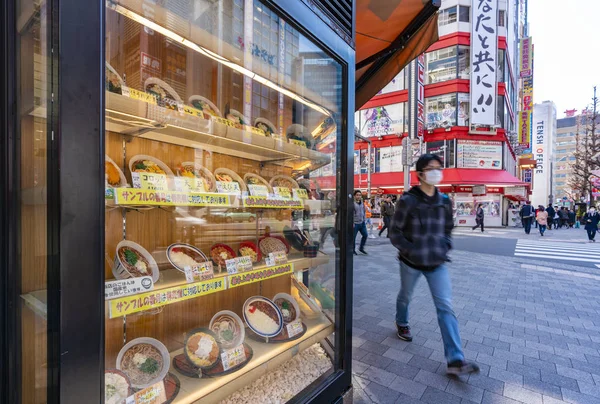 Man walking past a japanese in Tokyo — Stock Photo, Image