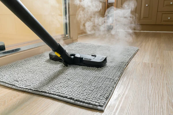 Cleaning bathroom mat using steam cleaner — Stock Photo, Image