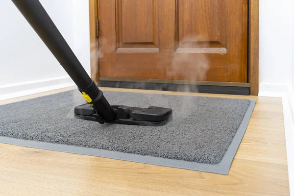 Sanitizing front doormat with steam cleaner — Stock Photo, Image