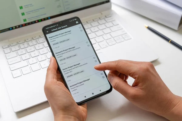 Buscar ofertas de empleo en el Reino Unido utilizando la aplicación para teléfonos inteligentes — Foto de Stock