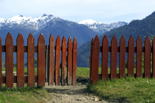 FENCE HALF OPEN IN THE TOP OF THE HILL WITH VIEWS TO THE MOUNTAINS