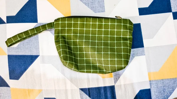 Small green pouch with white line pattern