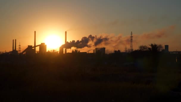 El humo de las pipas de fábrica sobre el fondo del sol al amanecer — Vídeos de Stock