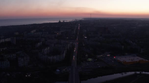 夜の都市を交通します 背景に海と夕焼け空 — ストック動画