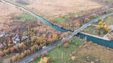 Hava video. Köprünün diğer tarafında küçük bir nehir üzerinde trafik. Sonbahar.