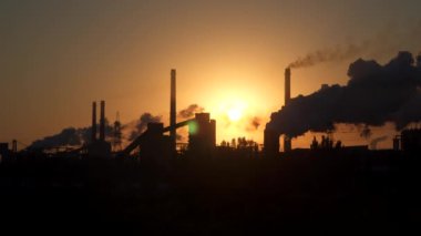 Şafak güneş arka plan üzerinde endüstriyel işletmenin borular.