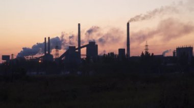 Metalurji tesisi gündoğumu gökyüzüne karşı binaların siluetleri