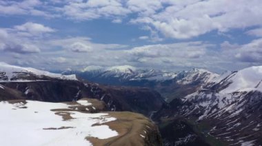 Yamaç paraşütü karla kaplı dağların arasında uçar. Drone tarafından çekilen video