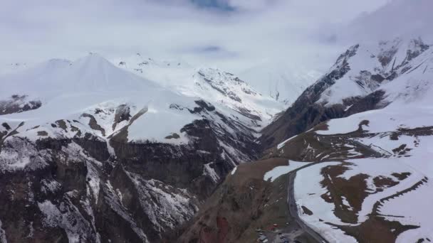 パラグライダーは雪に覆われた山々の中を飛ぶ ドローンで撮影したビデオ — ストック動画