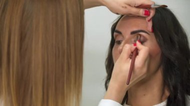 Model öğelere göz farı makyaj uygulamak makyaj göz sanatçıdır.