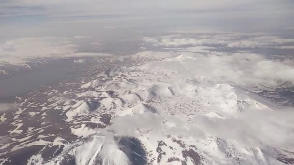 コーカサスの雪に覆われた山々の飛行機のポートホールからの眺め — ストック動画