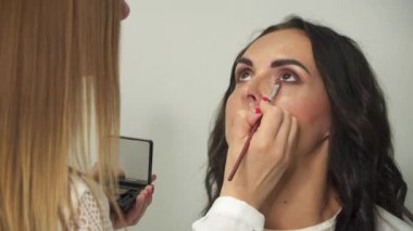 Usta profesyonel makyaj yapar. Mankenin gözlerine makyaj yapan makyaj sanatçısı. Göz makyajı.