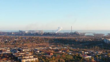 Nehir ve deniz kıyısında çelik fabrikası. Havadan görünüm. Şehirde sis var. Çevre kirliliği