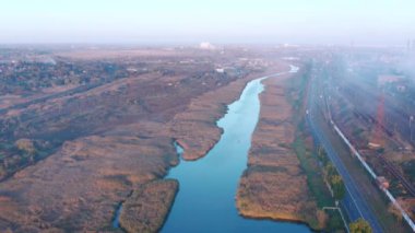 Çevre sorunları. Şehirdeki bir nehir üzerindeki metalürjik bir bitkiden duman. Akşam vakti. Havadan görünüm