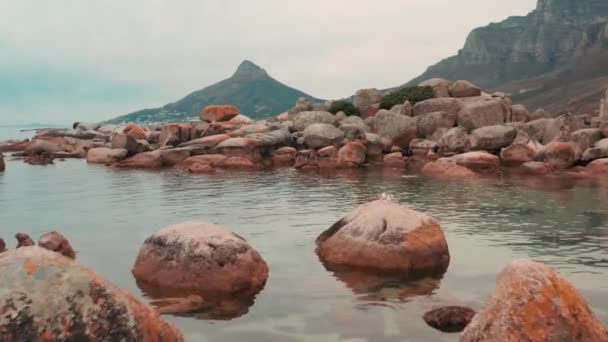 Валуны скалы, лежащие вдоль побережья моря — стоковое видео