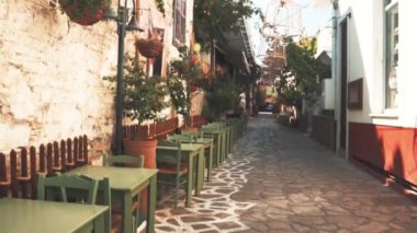 Masaları ve freskleri olan eski bir kaldırım taşı sokağı.