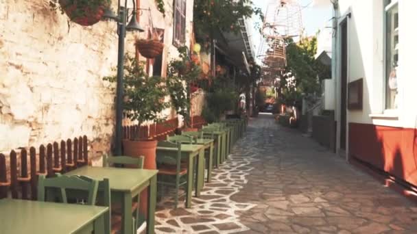 A quaint cobblestone alley with tables and chairs al fresco — Stock Video