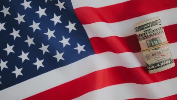 미국 국기 위에 돈을 올려 놓고 누워 있는 모습 — 비디오