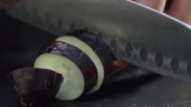 Bir patlıcanı bıçakla dilimlemek.