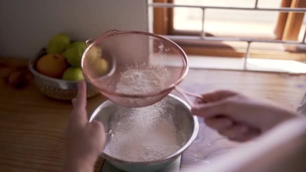 En person som anstränger det mjöl som ska användas vid bakning — Stockvideo