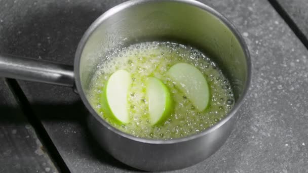 Kokande äppelskivor i en sirap — Stockvideo