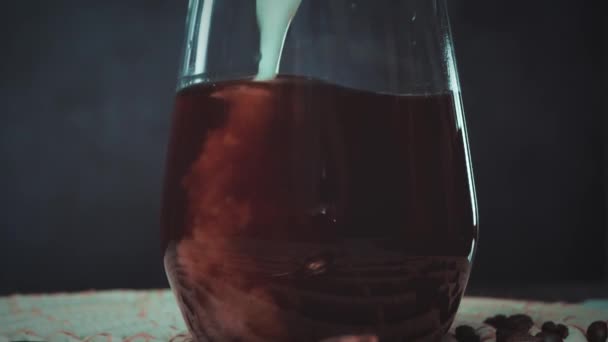 Vue rapprochée du café noir dans un verre rempli de lait — Video