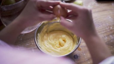 Bir hamura yumurta ekleyen kişi