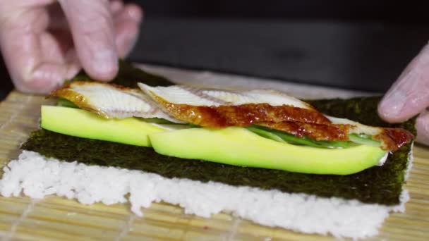 Om att göra sushirulle av grillad ål och avokado — Stockvideo