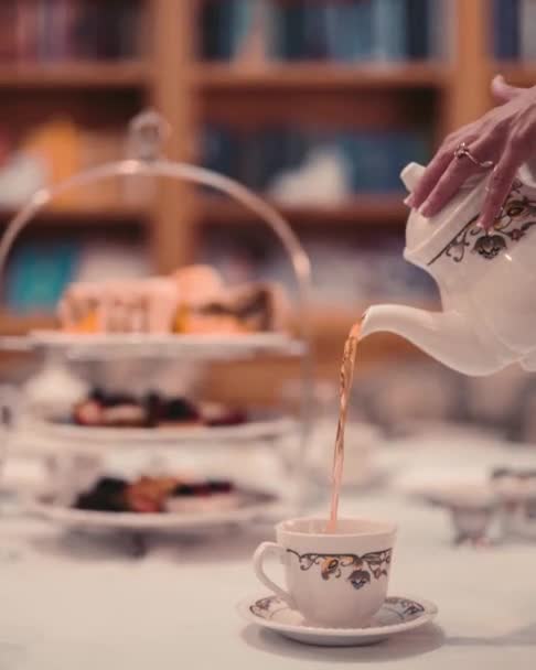Verter té caliente en una taza de porcelana — Vídeo de stock