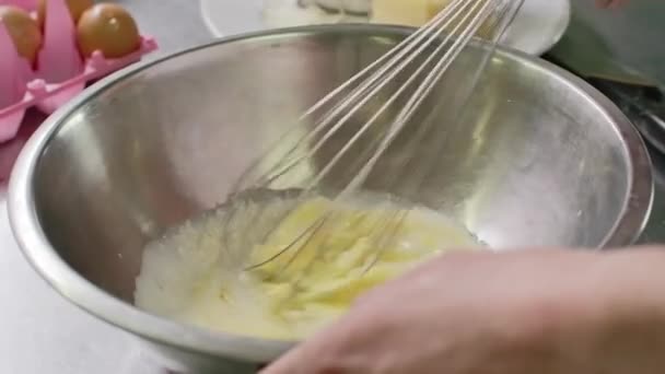 Çırpılmış yumurta ve süt bir kasede astirer kullanarak. — Stok video