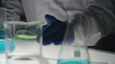 Laboratuvarda sıvı üzerinde çalışan insanlar.