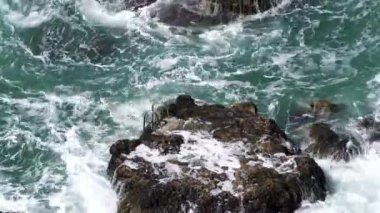 Dalgalar kayalara çarpıyor.