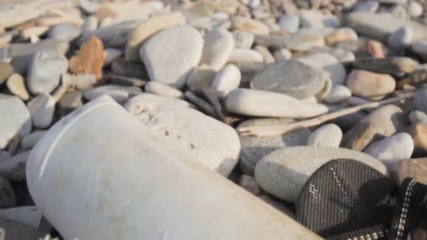 Resíduos deitados sobre pedras de seixos — Vídeo de Stock