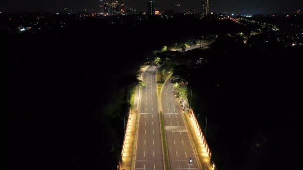 Aerial footage of well lighted city streets traffic and surrounding landscape — Stock Video