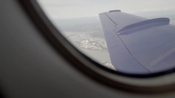 Vänster vinge på ett luftburet flygplan sett genom änkan — Stockvideo