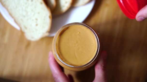 Woman opens a jar of peanut butter — Stock Video