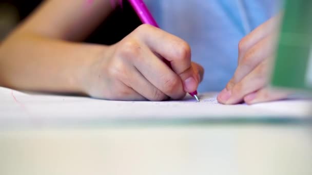 Linda niña está escribiendo usando un bolígrafo en preescolar — Vídeos de Stock