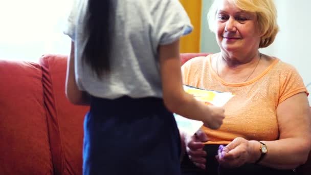 Bambina dando a sua nonna un disegno che ha disegnato — Video Stock