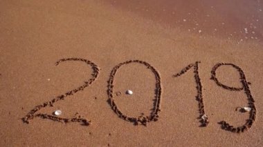 2019 kumda bir dalga tarafından yıkanmış olan kum çizilmiş